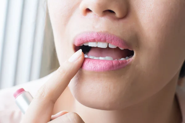 Kadın pembe ruj uygulanıyor. Yüzündeki yakından görmek