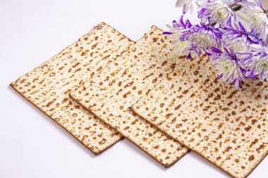 Hamursuz Bayramı arkaplanı matza, beyaz ve mor kasımpatılar. Yahudi tatili. Yukarıdan bak. Hamursuz Bayramı Hamursuz Bayramı kutlaması konsepti.