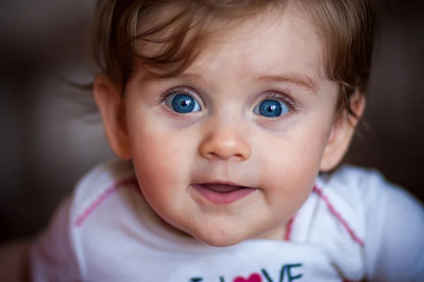 Kleines Baby blickt lächelnd in die Kamera. — Stockfoto