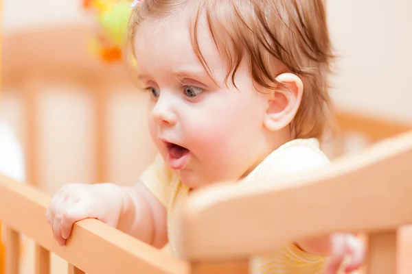 Bambino piccolo con una forcina in piedi in culla . — Foto Stock