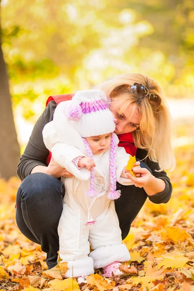秋天，年轻的妈妈和她蹒跚学步的女儿玩得很开心. — 图库照片