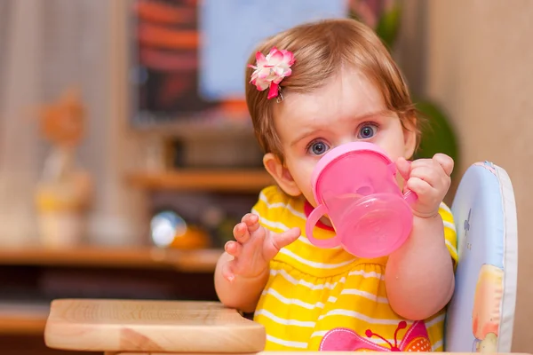 Little girl sitting at the table. drink water. — Stock Photo, Image