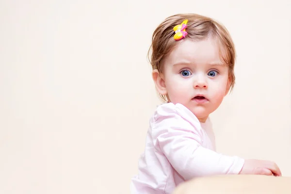 Liten flicka står nära i soffan hemma. — Stockfoto