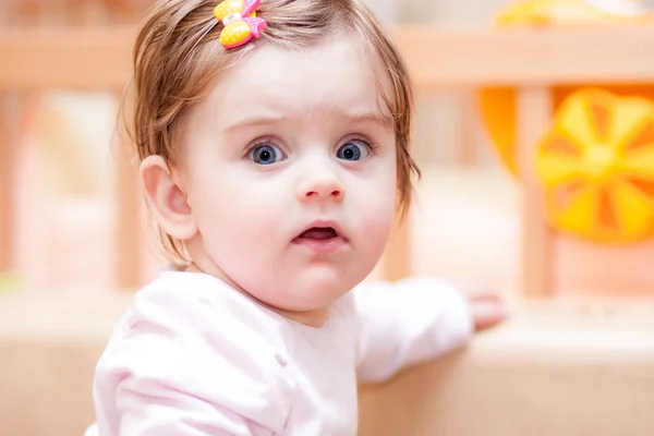 Little girl stands near the sofa at home. — Stock Photo, Image