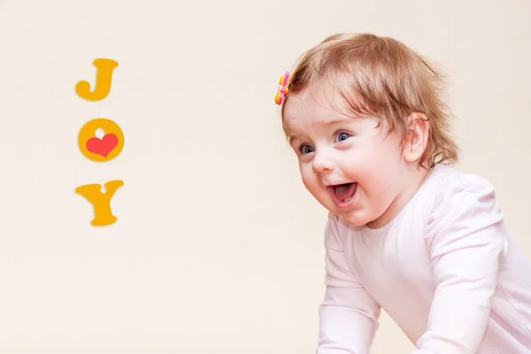 Little girl stands near the sofa at home. — Stock Photo, Image