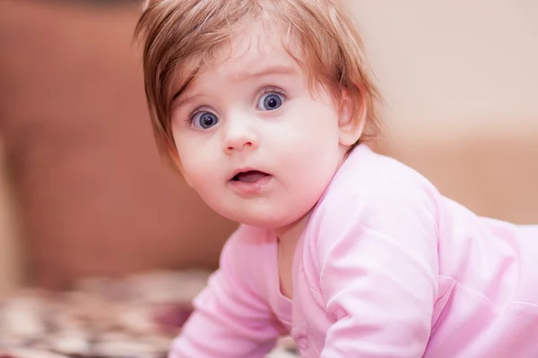 Little baby lying on the blanket and showing tongue. — Stock Photo, Image