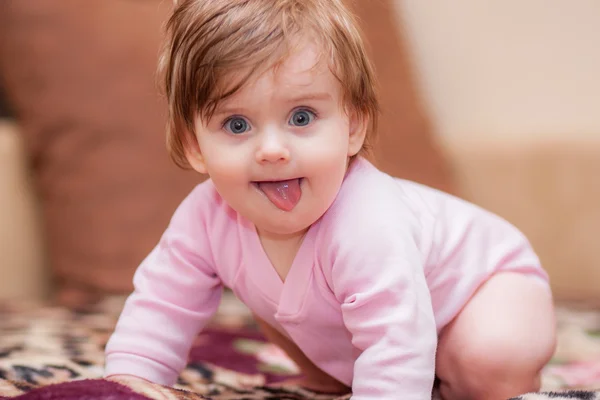 Little baby lying on the blanket and showing tongue. — Stock Photo, Image