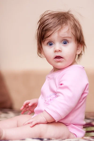 Pequeno bebê deitado no cobertor e mostrando língua . — Fotografia de Stock