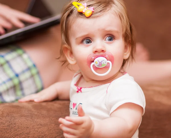 Little girl stands near the sofa — Stock Photo, Image