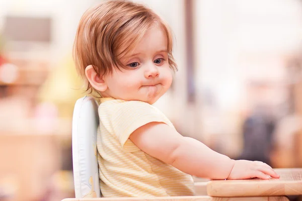 Bambina seduta su una sedia di legno — Foto Stock