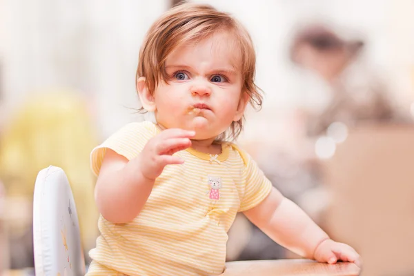 Little girl sitting on a wooden chair — Stock Photo, Image