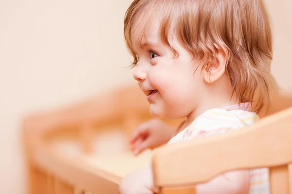 Little girl standing in the crib — Stock Photo, Image