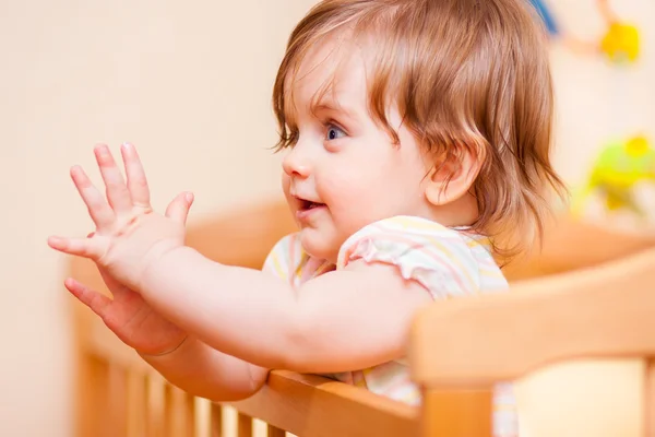 Little girl standing in the crib — Stock Photo, Image