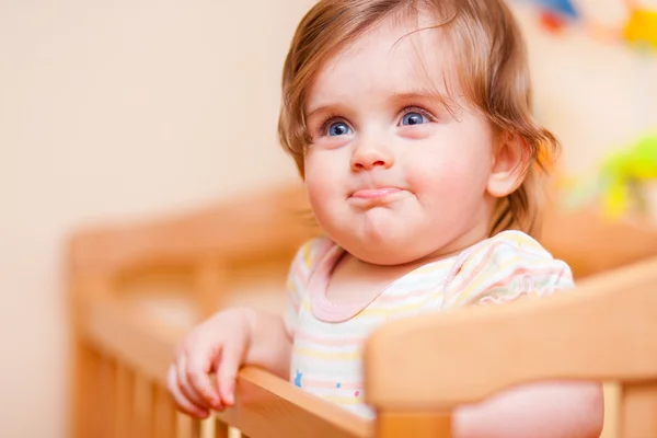 Little girl standing in the crib — Stock Photo, Image