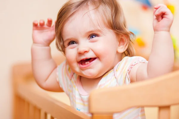 Little girl standing in the crib — Stock Photo, Image