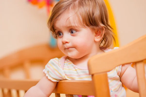 Little girl standing in the crib — Stock Photo, Image