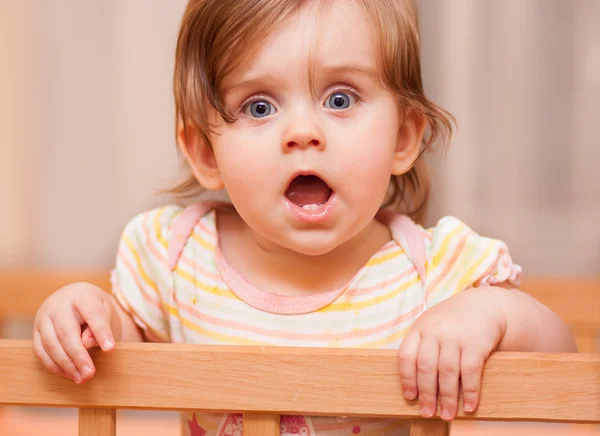 Little girl standing in the crib — Stock Photo, Image