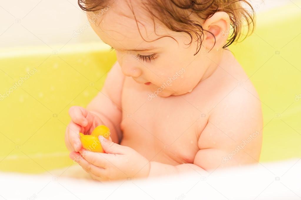 small child sitting in the bath