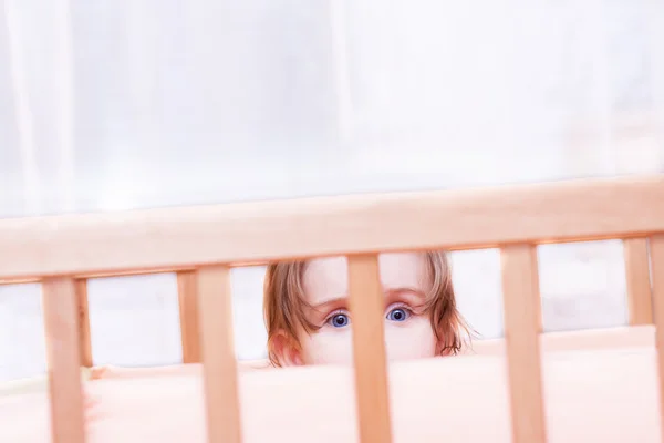 Little girl sits in the crib — Stock Photo, Image