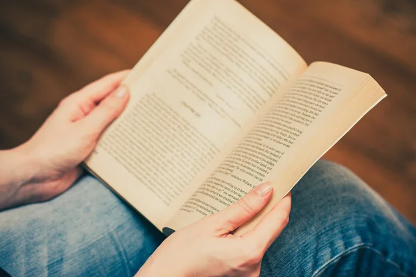 Kız oturan ve bir kitap okuma kot pantolon.