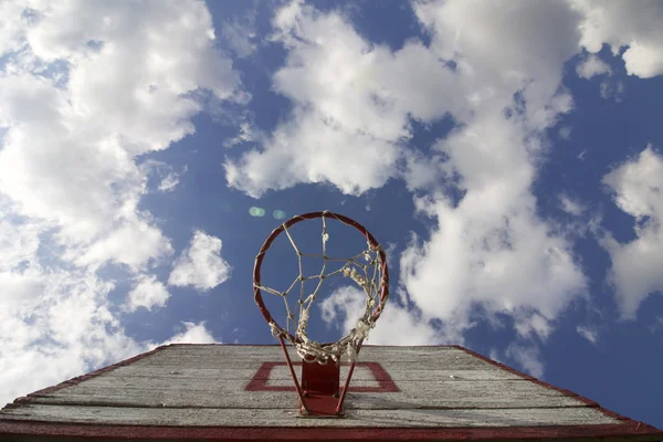 Placa de basquetebol com rede. Tábuas de madeira velhas. Pintado. Localizado em um fundo de céu azul com nuvens. Jogos desportivos no quintal. Vista de baixo do anel . — Fotografia de Stock