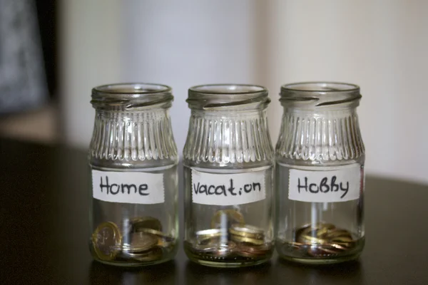 Three jars - piggy bank. In the miscellaneous expenses. They are glued to the tape to write her goal of spending. At the bottom poured a bit of coins. Budget Management.