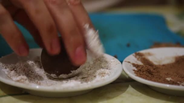 A mulher faz doces. Deliciosas trufas. Boned em uma mistura doce de açúcar em pó e baunilha — Vídeo de Stock