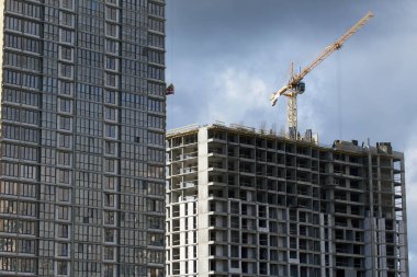 Modern çok katlı binaların yapımı. Yerleşim alanının yeni gelişimi. İnşaat alanında ev iskeletleri ve inşaat vinçleri.