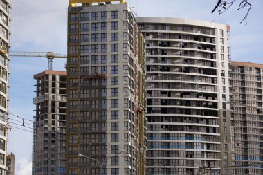 Modern çok katlı binaların yapımı. Yerleşim alanının yeni gelişimi. İnşaat alanında ev iskeletleri ve inşaat vinçleri.