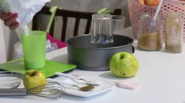Bir kadın mutfak terazisinde un tartar. Charlotte 'u yapmak için gerekli malzeme ve malzemeler. Elmalı turta..