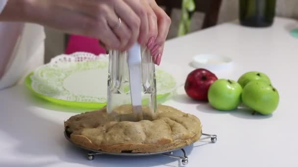 La femme sort un verre du centre de la charlotte cuite au four. Plusieurs pommes à proximité. — Video