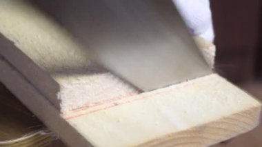 Kesme çizgisi boyunca bir adam tahtayı kesiyor. Sebze toplamak için bir depolama kutusu yapıyor. Bir apartman dairesinde salgın sırasında sebze toplamak. Yakın çekim.