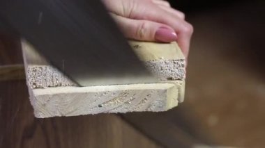 Bir adam tahta tahtayı bıçakla kesiyor. Sebze toplamak için bir depolama kutusu yapıyor. Bir apartman dairesinde salgın sırasında sebze toplamak. Yakın çekim..