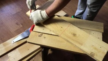 Adam ölçümleri mezurayla kontrol ediyor ve kırmızı kalemle kesme çizgisini işaretliyor. Sebze toplamak için bir depolama kutusu yapıyor. Bir apa şehrinde salgın sırasında sebze toplamak.