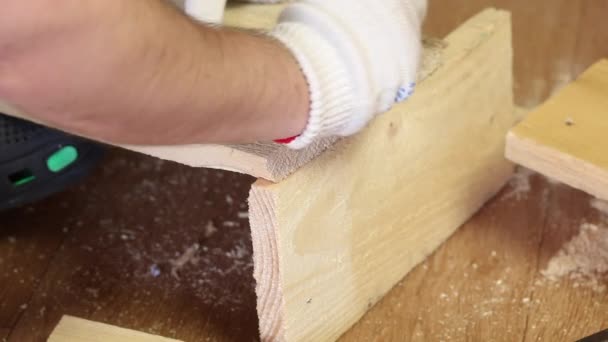 El hombre derriba las tablas con clavos. Hace una caja de almacenamiento para la cosecha de verduras. Cosechar verduras durante la epidemia en un apartamento de la ciudad.. — Vídeo de stock