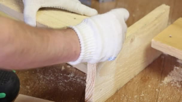 El hombre derriba las tablas con clavos. Hace una caja de almacenamiento para la cosecha de verduras. Cosechar verduras durante la epidemia en un apartamento de la ciudad. — Vídeos de Stock