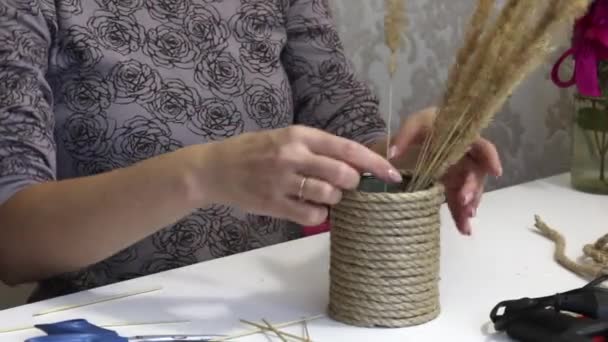 女性は乾燥ハーブの花束を収集します。近くにはロープで包んだことができる錫があります。自己分離の工芸品 — ストック動画