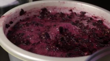 Kasede üzüm hamuru. Fermantasyon görülebilir. Salgın sırasında ev yapımı şarap yapmak. Yakın çekim..