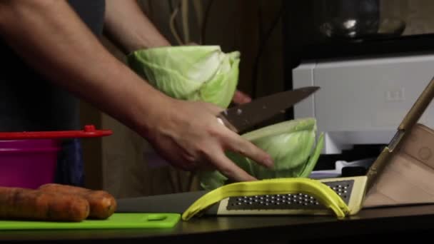 A man broadcasts the process of chopping cabbage via video link. Sauerkraut at home. On the table next to him are cabbage, carrots and cooking tools. Close-up shot.. — Stock Footage A man broadcasts the process of chopping cabbage via video link. Sauerkraut at home. On the table next to him are cabbage, carrots and cooking tools. Close-up shot.. Stock Video