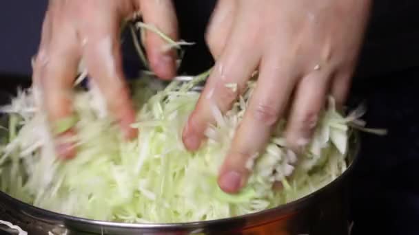 Un hombre está amasando repollo rallado con sus manos en una cacerola. Sauerkraut en casa durante una pandemia. — Vídeo de stock