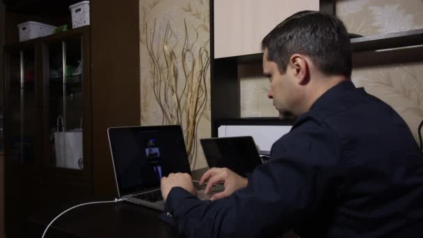 En man tittar på en videokonferens på en laptop. Beläget i en lägenhet i självisolering. — Stockvideo