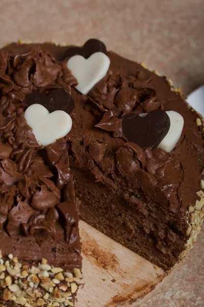 Schokoladenkuchen Mit Sahne Und Erdnüssen Mit Schokoladenherzen Dekoriert Auf Kiefernbrettern — Stockfoto