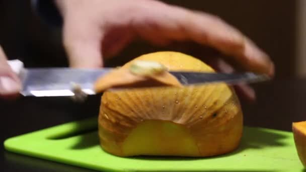 一个人用刀割一个小桔子南瓜.侧身特写镜头. — 图库视频影像