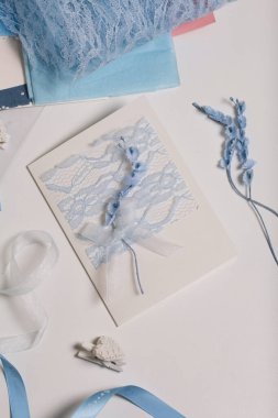 Tebrik kartları hazırlıyorum. Masanın beyaz yüzeyinde el işi aksesuarlar. Kurumuş çiçekler ve el işleri için kurdeleler. Yaratıcılık için araçlar.