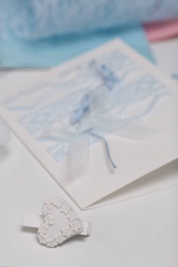 Tebrik kartları hazırlıyorum. Masanın beyaz yüzeyinde el işi aksesuarlar. Kurumuş çiçekler ve el işleri için kurdeleler. Yaratıcılık için araçlar.