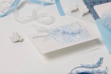 Tebrik kartları hazırlıyorum. Masanın beyaz yüzeyinde el işi aksesuarlar. Kurumuş çiçekler ve el işleri için kurdeleler. Yaratıcılık için araçlar.