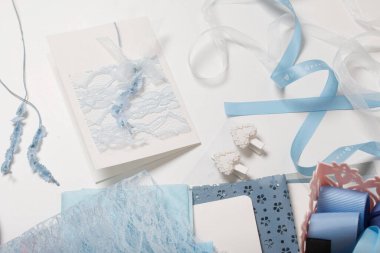 Tebrik kartları hazırlıyorum. Masanın beyaz yüzeyinde el işi aksesuarlar. Kurumuş çiçekler ve el işleri için kurdeleler. Yaratıcılık için araçlar.