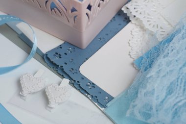 Tebrik kartları hazırlıyorum. Masanın beyaz yüzeyinde el işi aksesuarlar. Kurumuş çiçekler ve el işleri için kurdeleler. Yaratıcılık için araçlar.