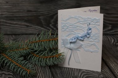 Köknar dalları arasında tebrik kartı. Siyah çam tahtalarında.