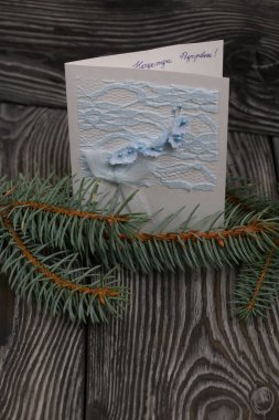 Köknar dalları arasında tebrik kartı. Siyah çam tahtalarında.